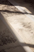 Close-up of delicate brushstrokes on a serene landscape painting with subtle black accents.