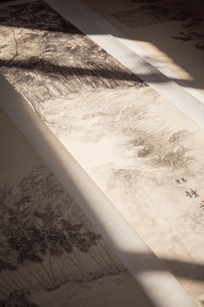 A traditional ink painting on paper depicting a serene landscape with lush trees. The brushstrokes create a sense of depth and movement. Soft shadows cast by light filtering through add an atmospheric touch.