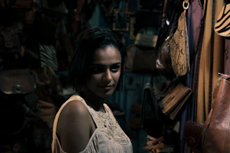 Moody cinematic portrait of a female entrepreneur in a cozy, dimly lit studio.