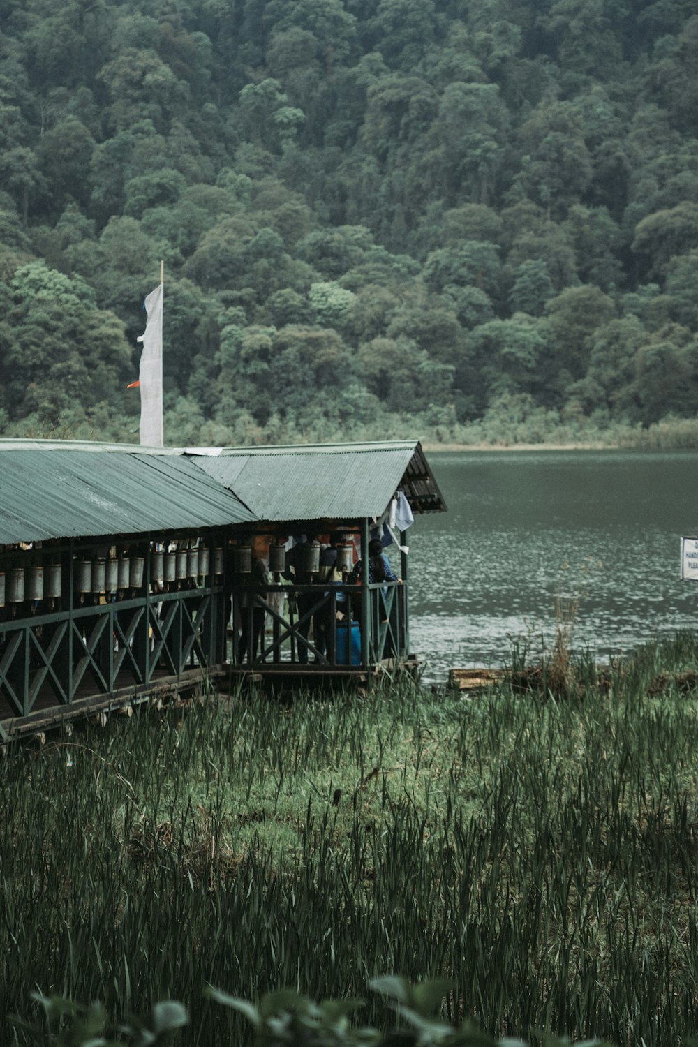 brown wooden hut beside body of water