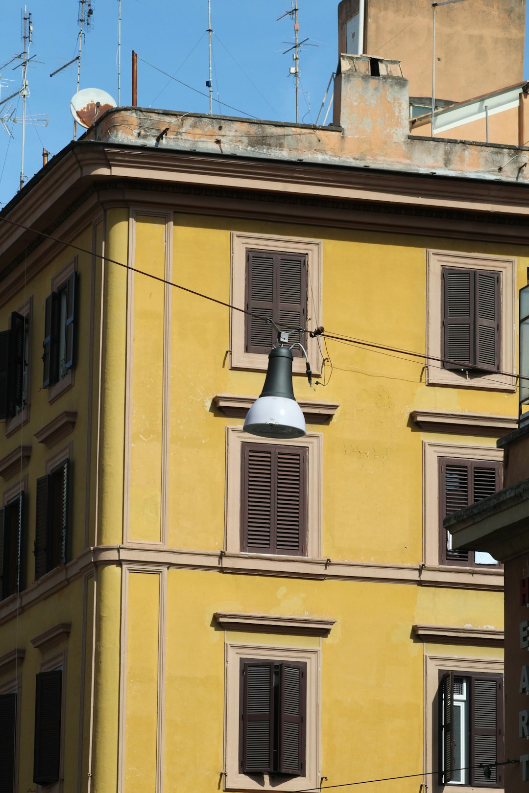 white and black pendant lamp beside brown building during daytime