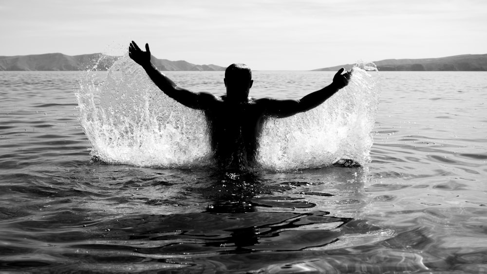 silhouette of person in body of water during daytime