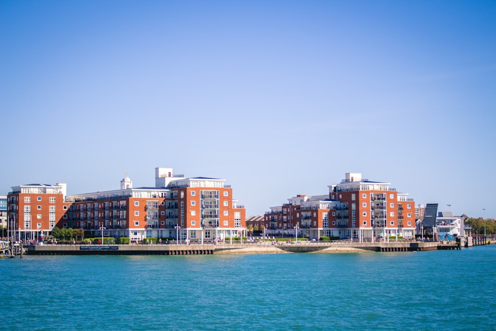 orange and white concrete buildings near body of water during daytime