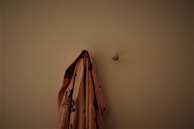 Adhesive curtain hooks holding lightweight fabric curtains on a bright kitchen window.