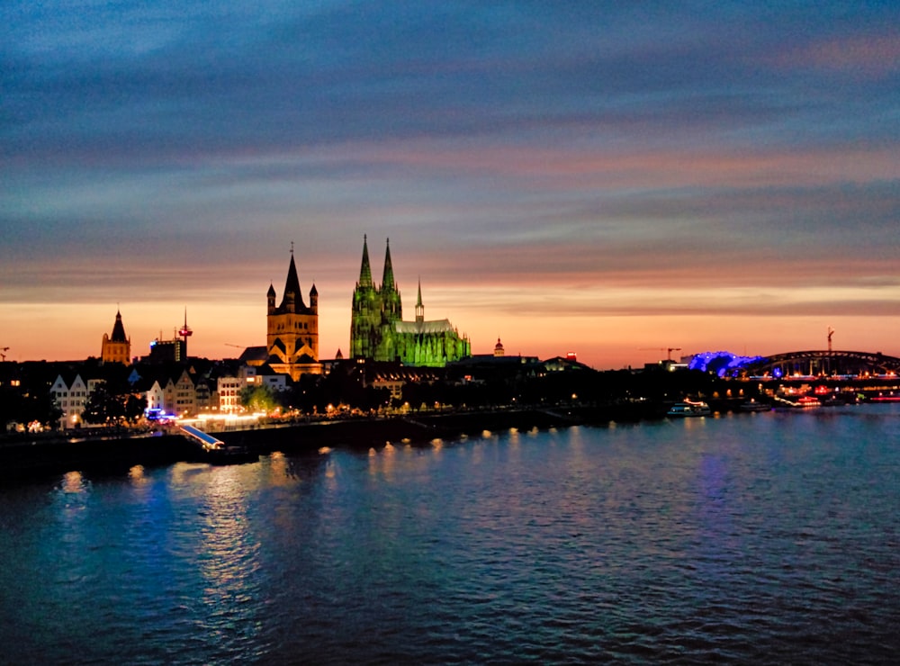 lighted city buildings near body of water