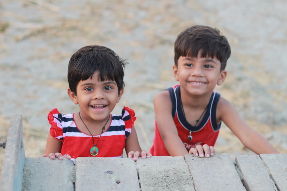 foto de enfoque superficial de niña y niño sonriendo