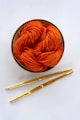 orange yarn on round white bowl