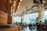 A cozy café interior with wooden tables and warm lighting, filled with happy customers.