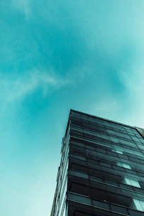 Spotless modern glass building facade shining under clear sky.