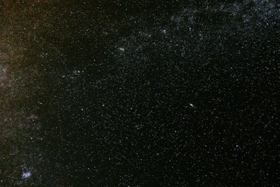 A vast starry sky filled with countless stars and cosmic dust, with a slightly visible nebula or galaxy in the distance creating a mysterious and expansive atmosphere.