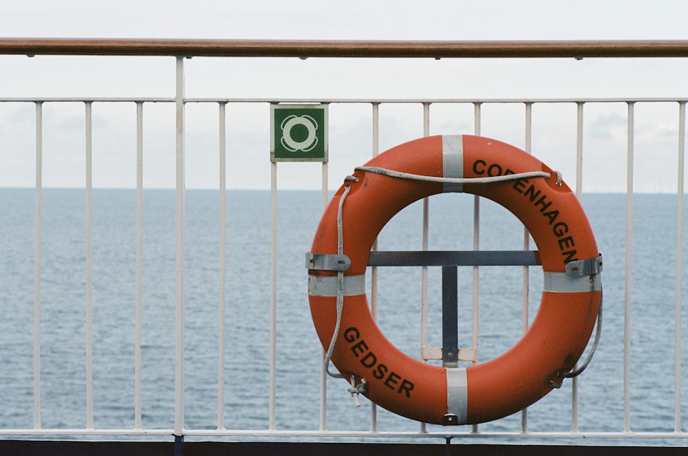 orange-weißer Kopenhagener Schwimmring in der Nähe der Wand