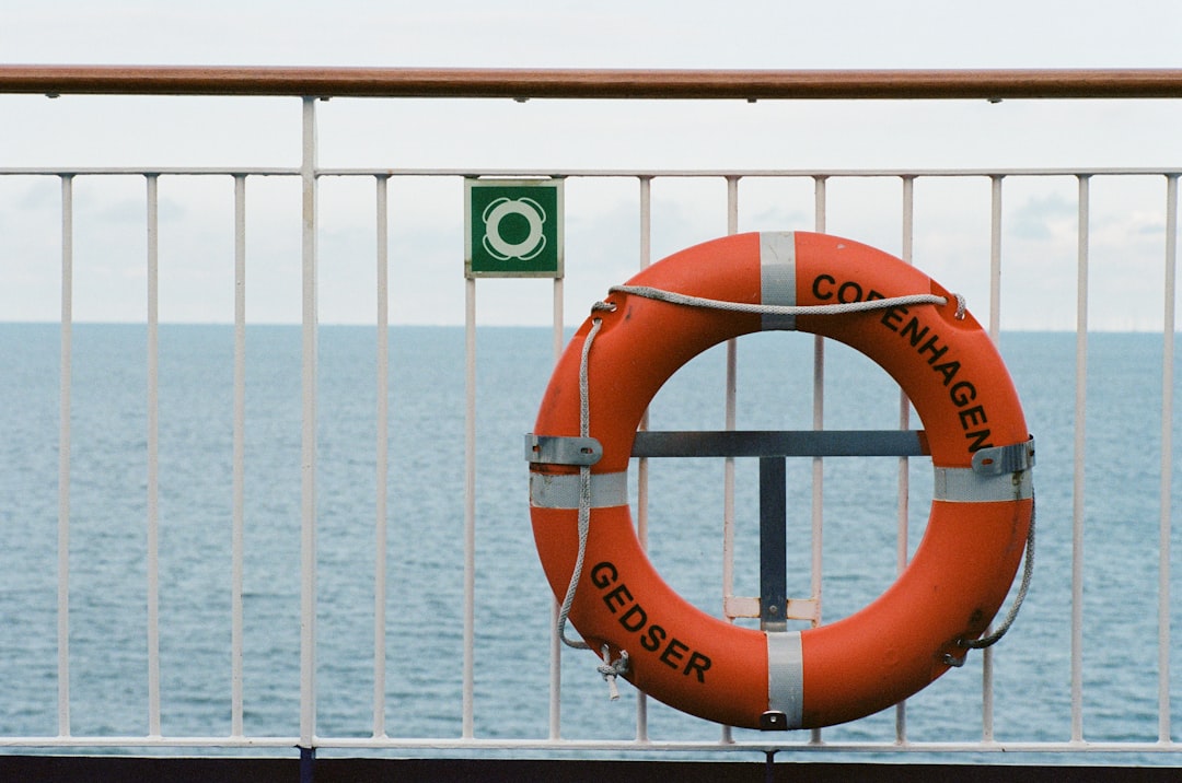 orange and white Copenhagen swim ring near wall