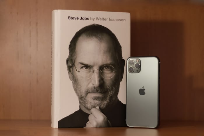 steve jobs on book cover, next to an iPhone