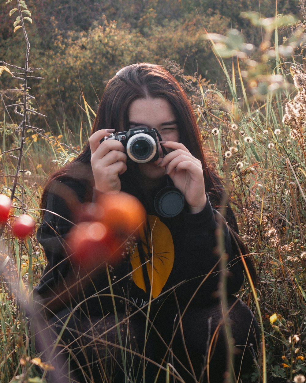 woman holding camera on field