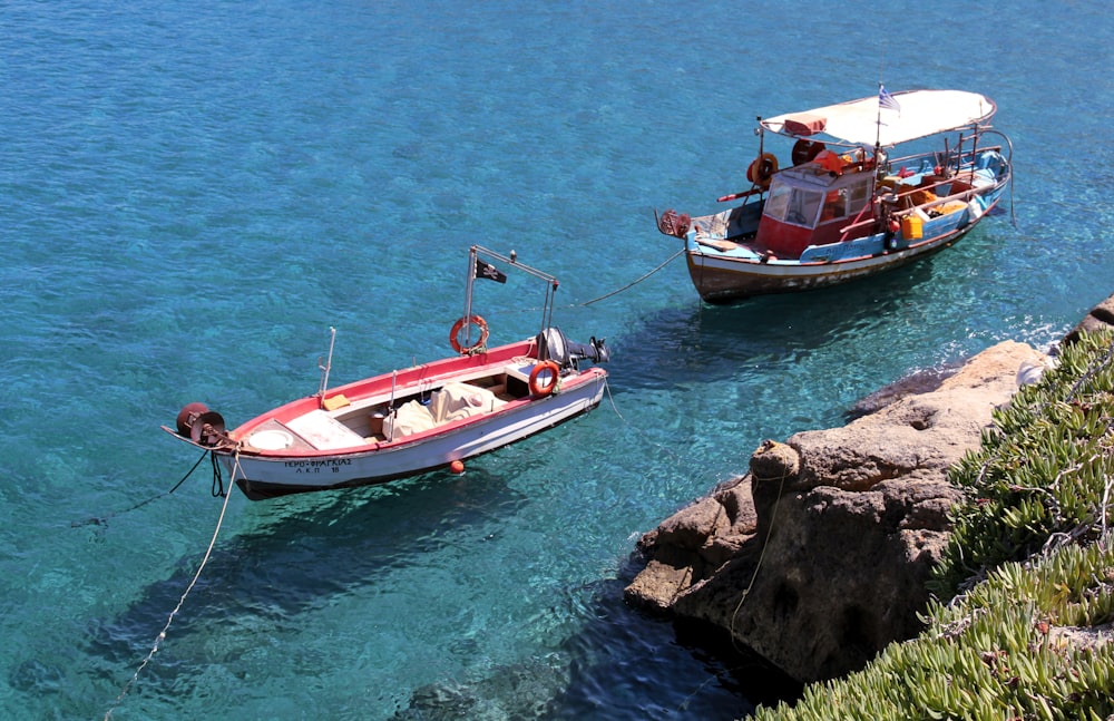 red and white boat and white motorboat