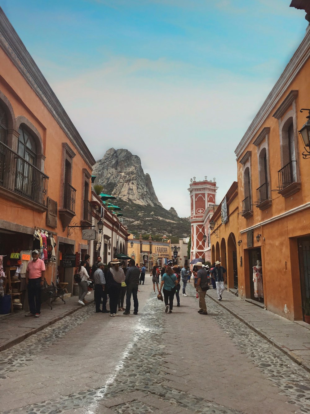 people walking on road between buildings