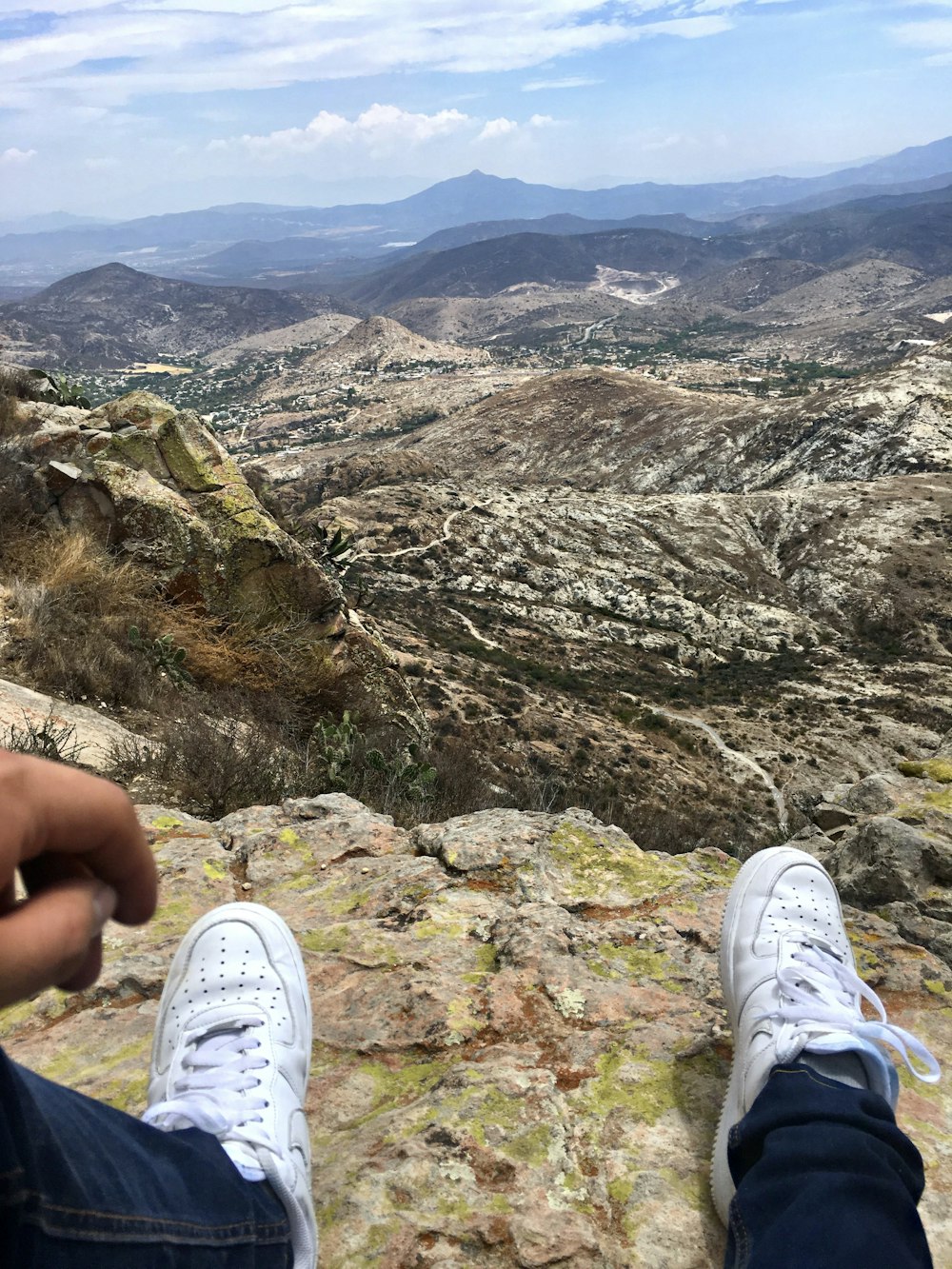 person sitting on mountain cliff during daytime