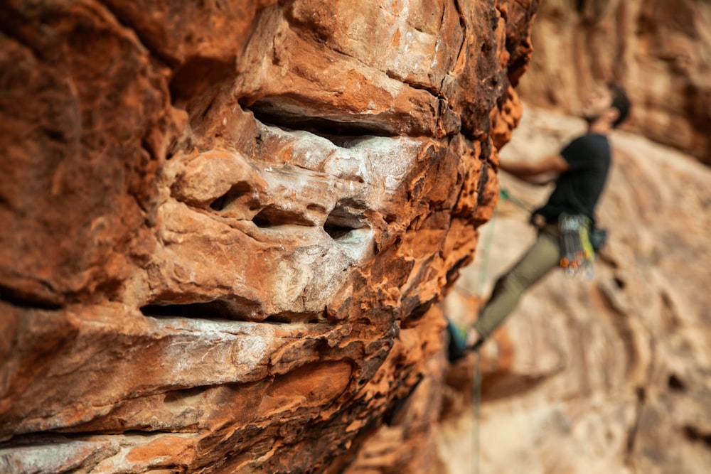 man wearing black crew-enck shirt and green pants mountain climbing