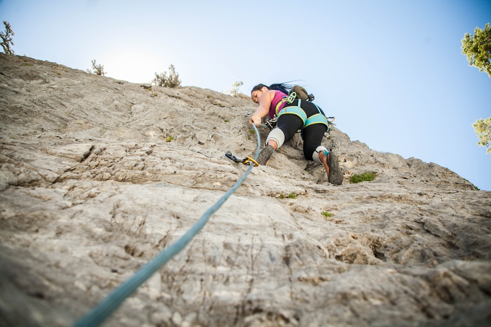 woman climbing on beige mountain