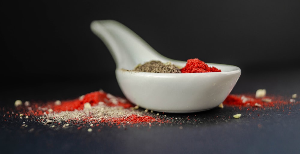 brown and red seasoning on white ceramic soup spoon