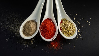 three assorted spices in white spoons