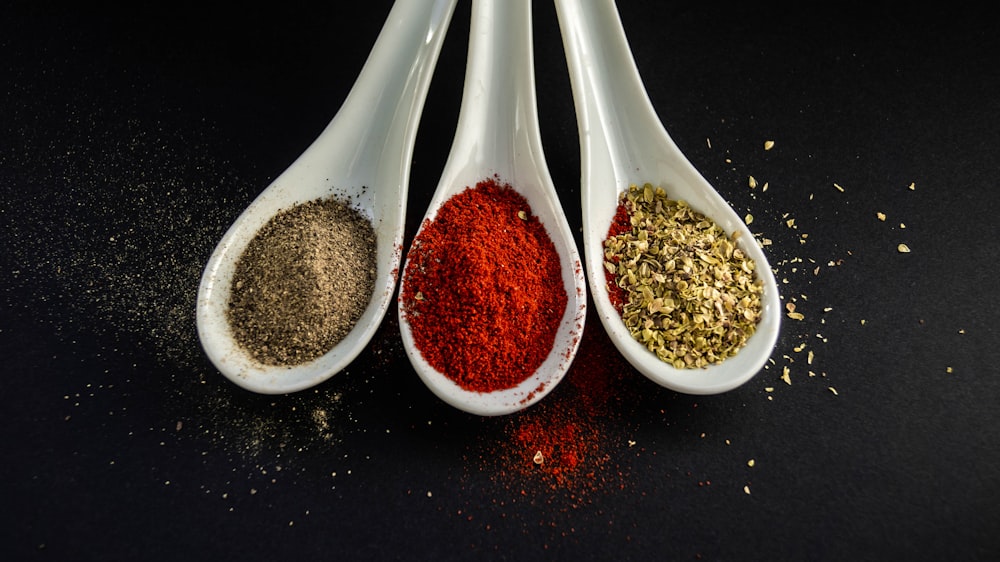 three assorted spices in white spoons