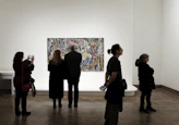 a group of people standing in front of a painting