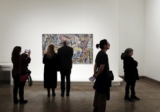 a group of people standing in front of a painting