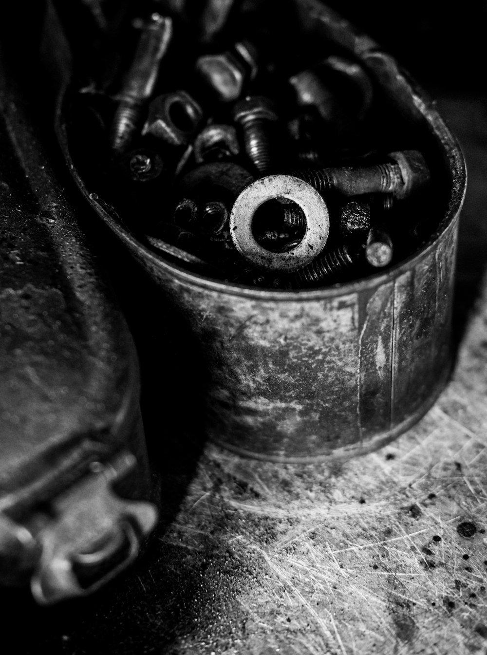 grayscale photo of screws and washers on can