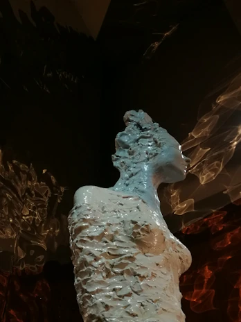 A finished ceramic sculpture displayed against a minimalist background, emphasizing its texture.