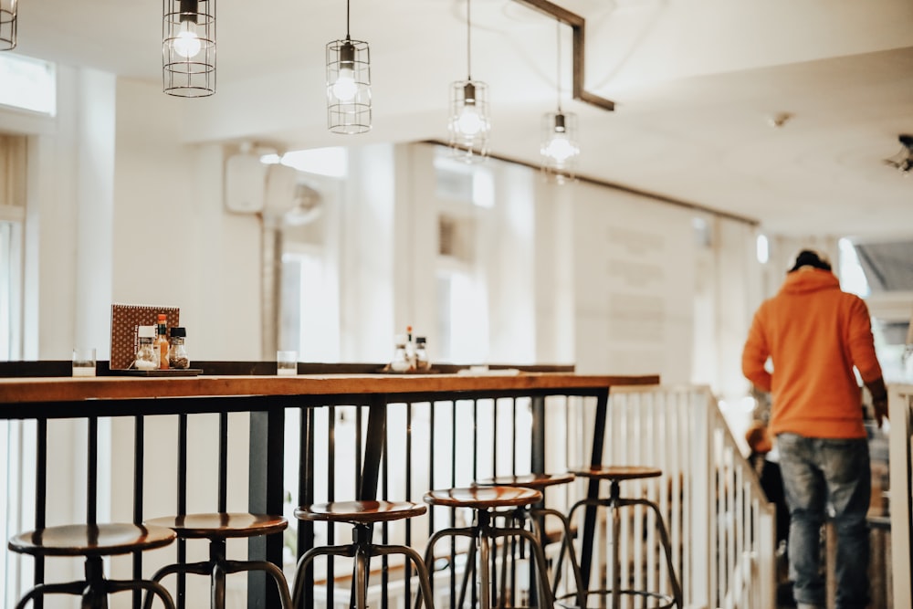 woman wearing orange jacket walking downstair