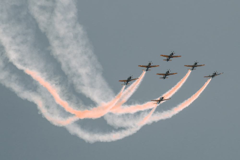 Flugzeuge mit orangefarbenen Kondensstreifen