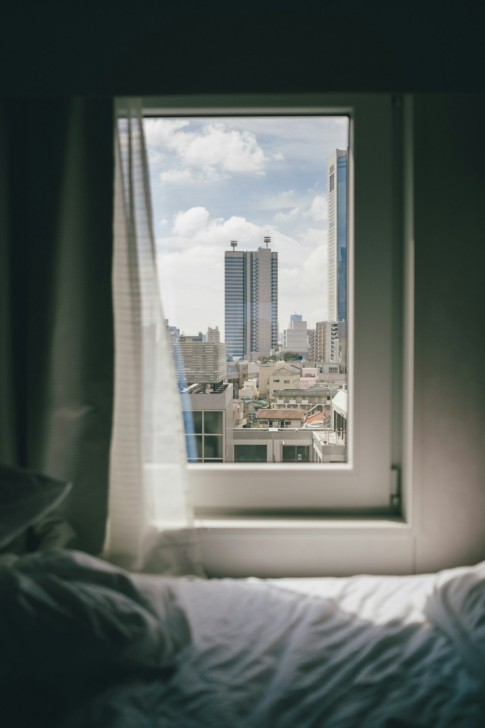 a view of a city from a bedroom window