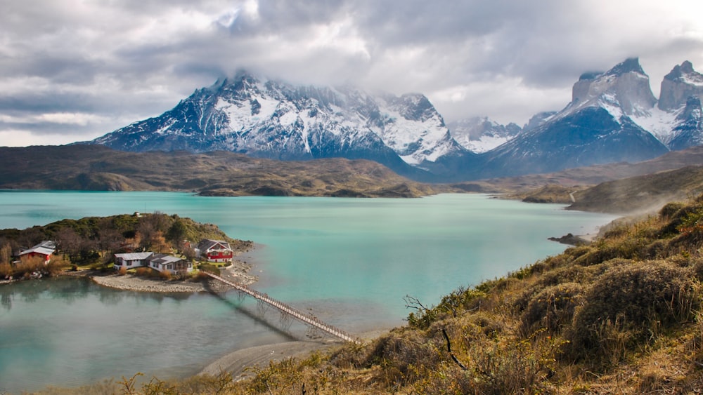 a small island in the middle of a lake with mountains in the background