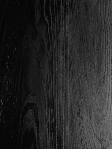Dark wood grain texture with visible lines and swirls, creating a natural pattern.