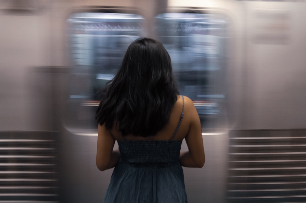 woman standing beside train