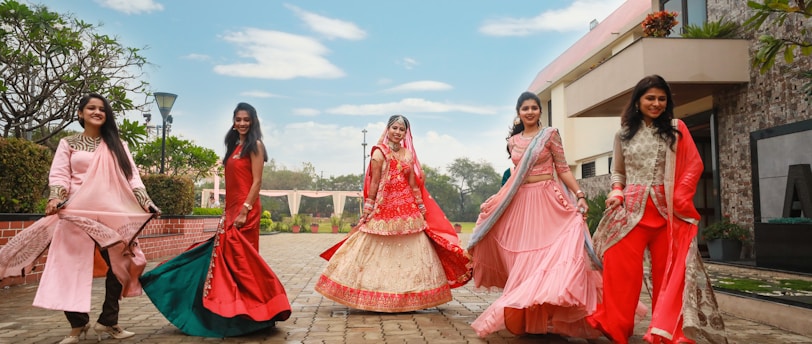 five women wearing red dress standing on pavement