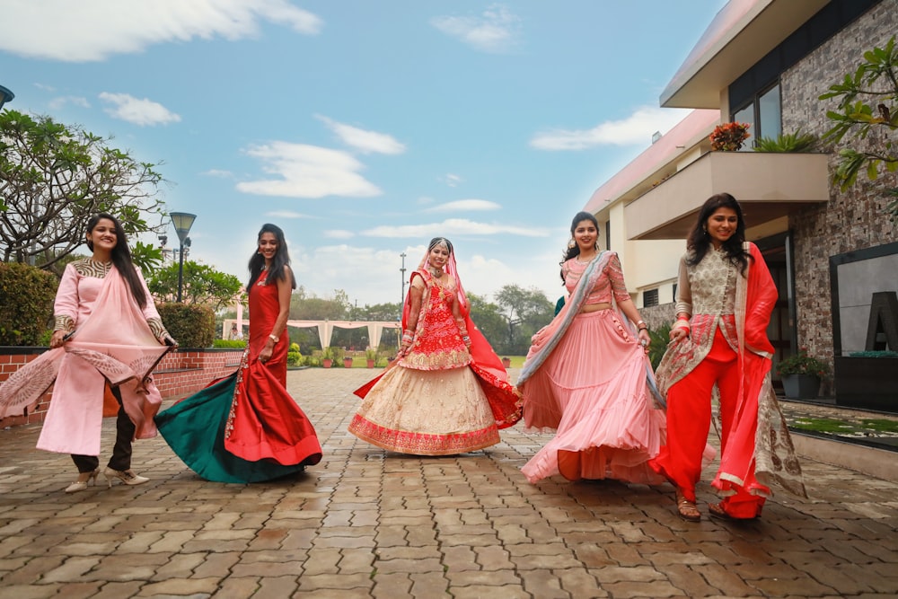 five women wearing red dress standing on pavement