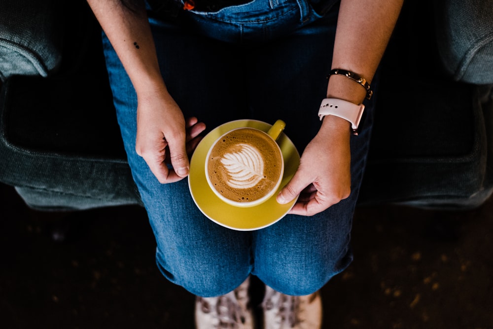 woman sitting on sofa holding teacup with coffee