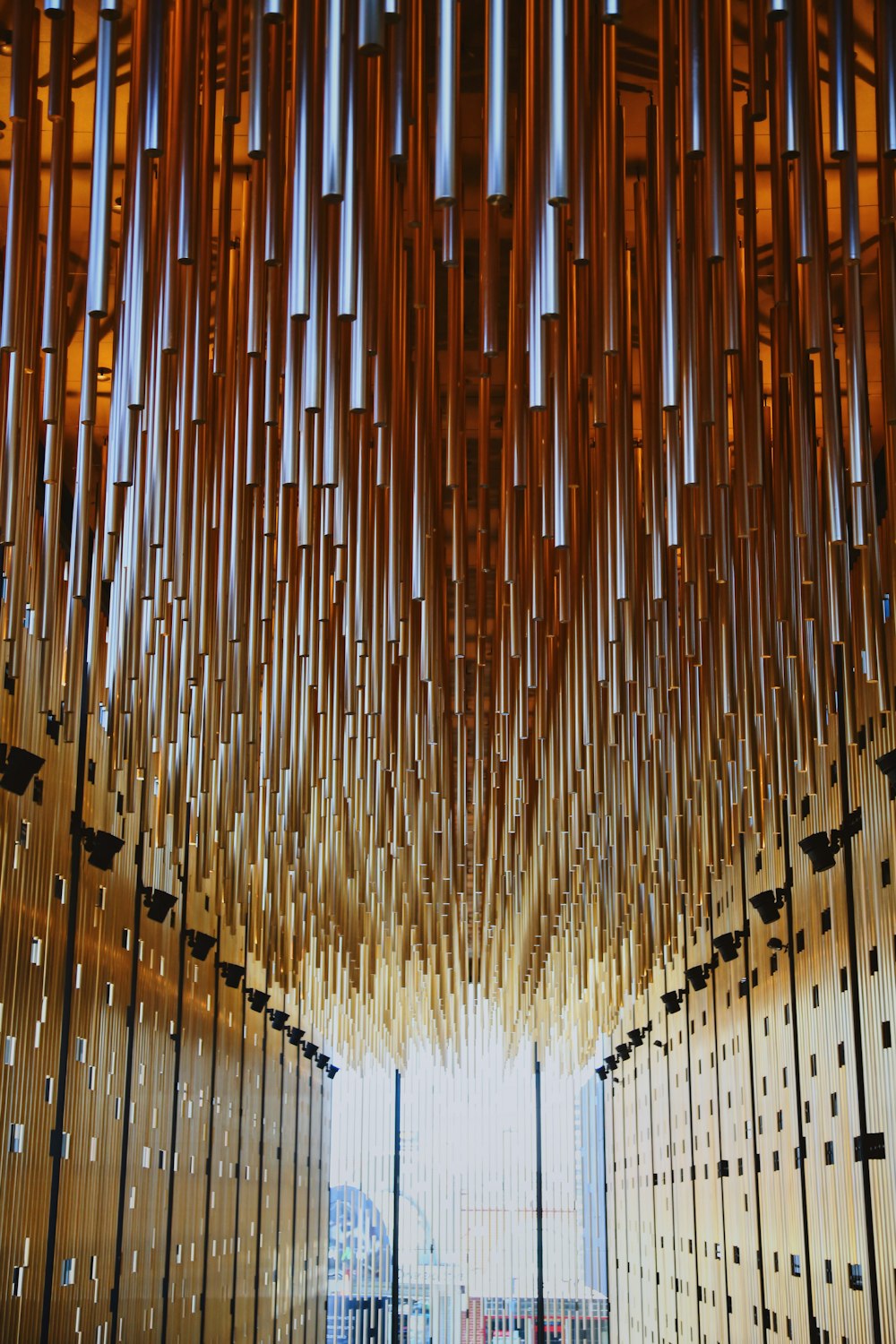 a room filled with lots of wooden pipes hanging from the ceiling