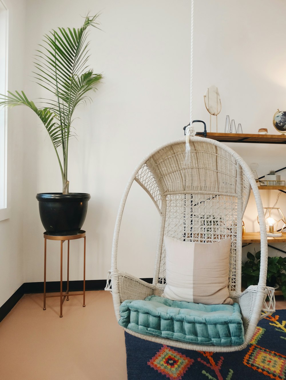 beige and blue egg chair near black potted plant