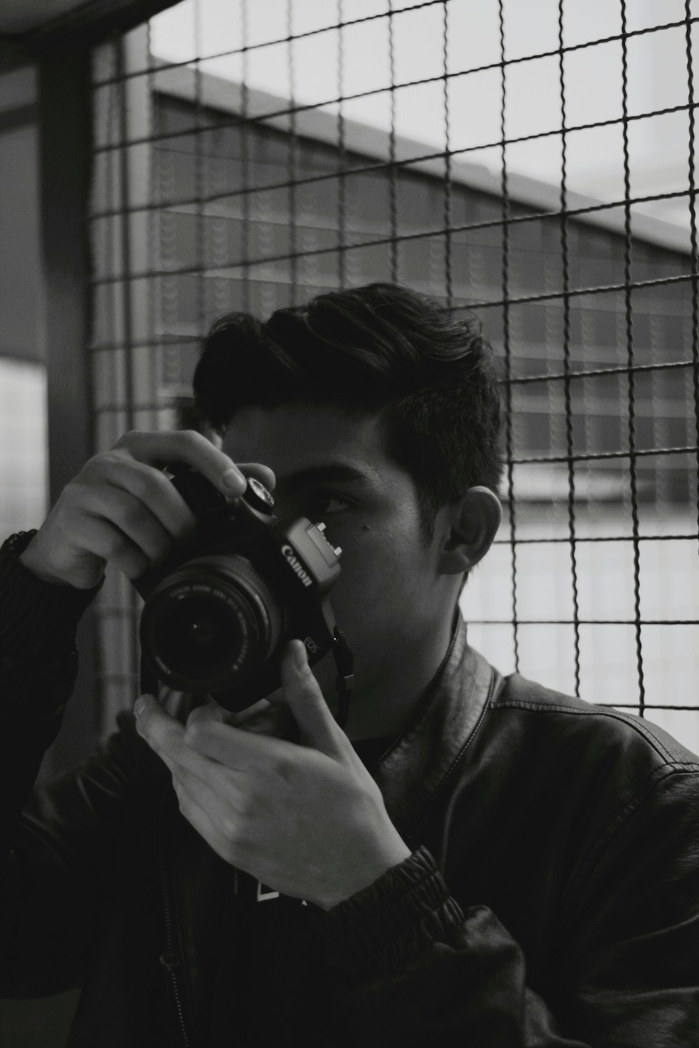 grayscale photography of man holding camera