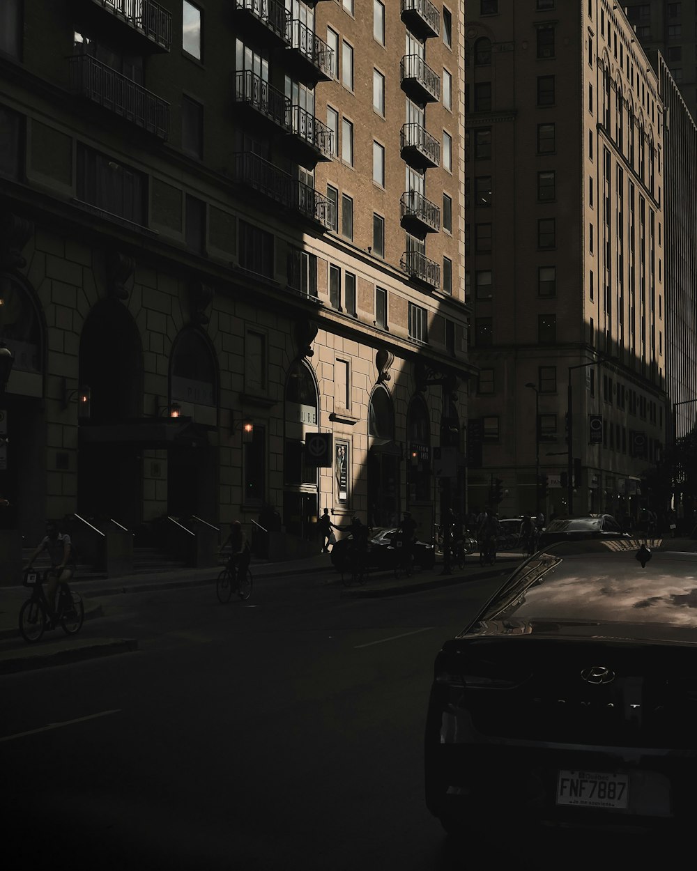 people riding bikes near cars on the road at the city during day