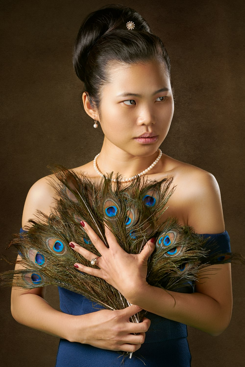 women's holding green feathers handfan