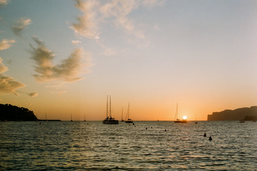 silhouette of boats on ocean during daytime