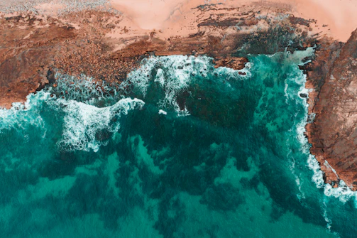 View of a rugged coastline with turquoise waves crashing against cliffs