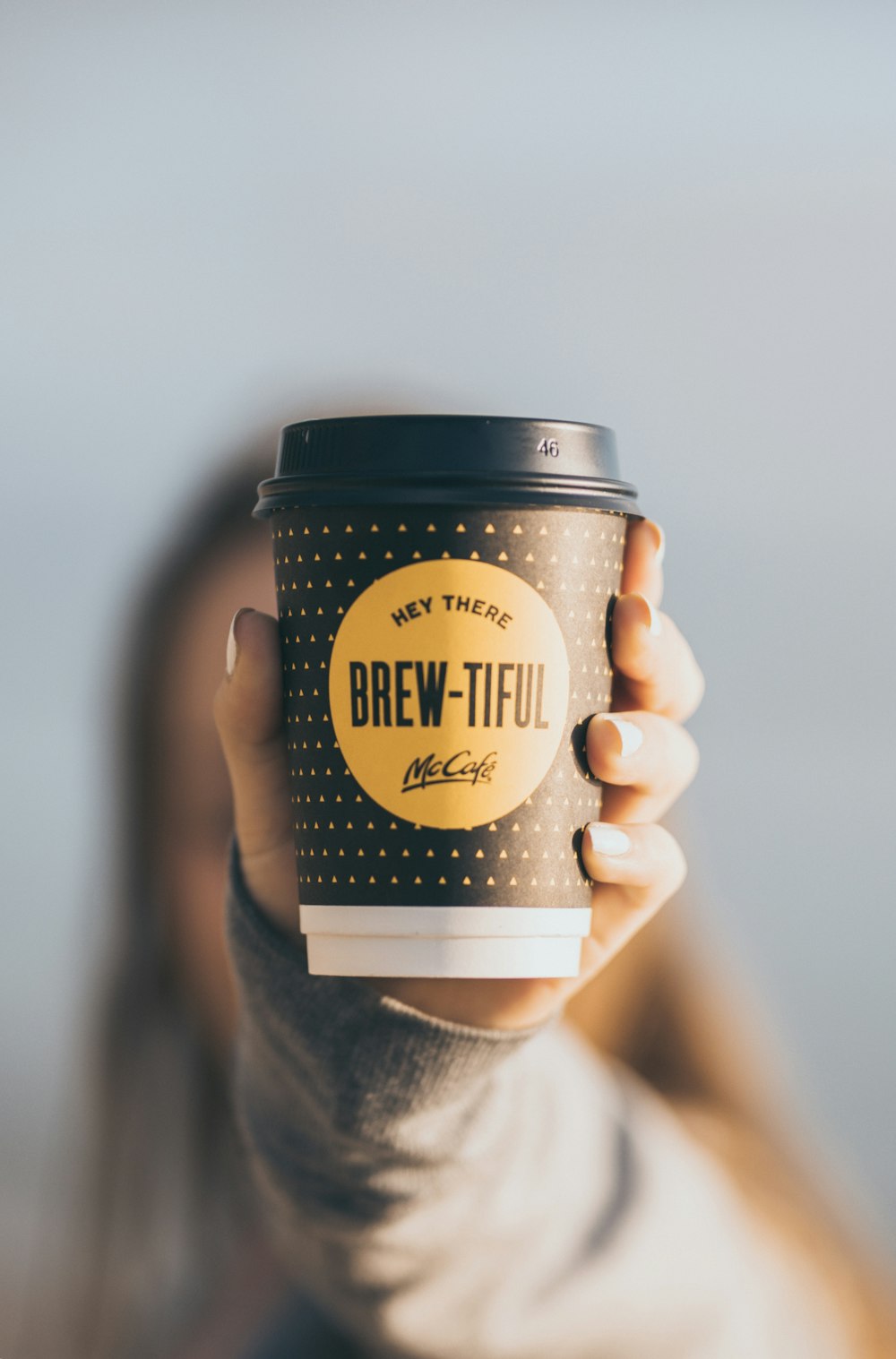 a woman holding up a cup of coffee