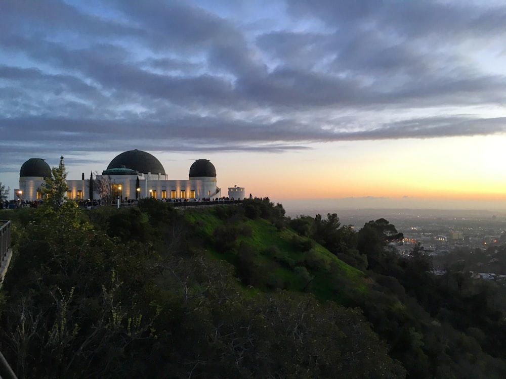 white and black dome building under cloudy sky during sunset