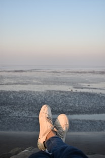 person wearing pair of white low-top sneakers
