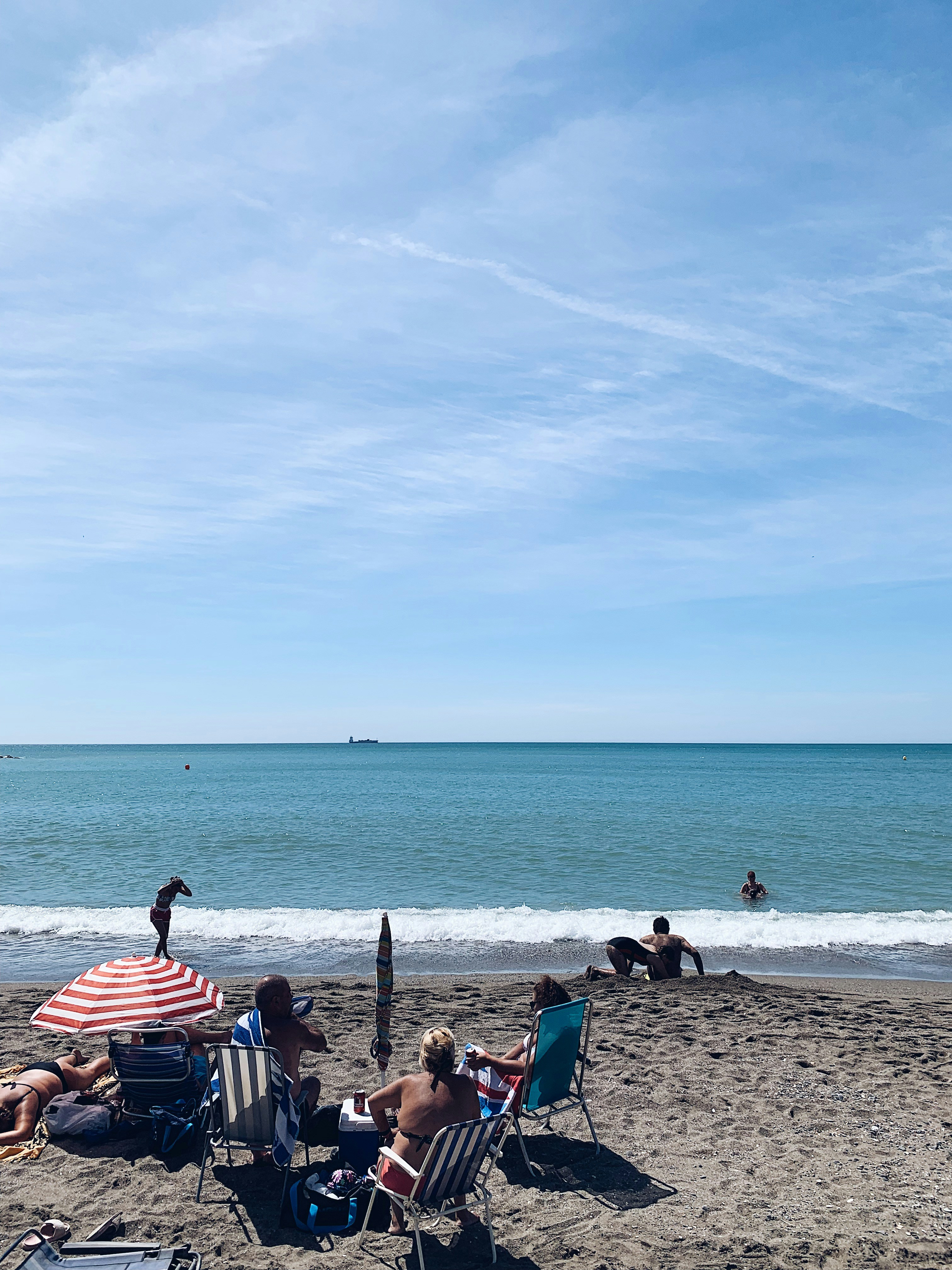 people sitting on beach chairs on beach during daytime